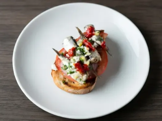 Брускетта з сардинами, фетою та томатами
